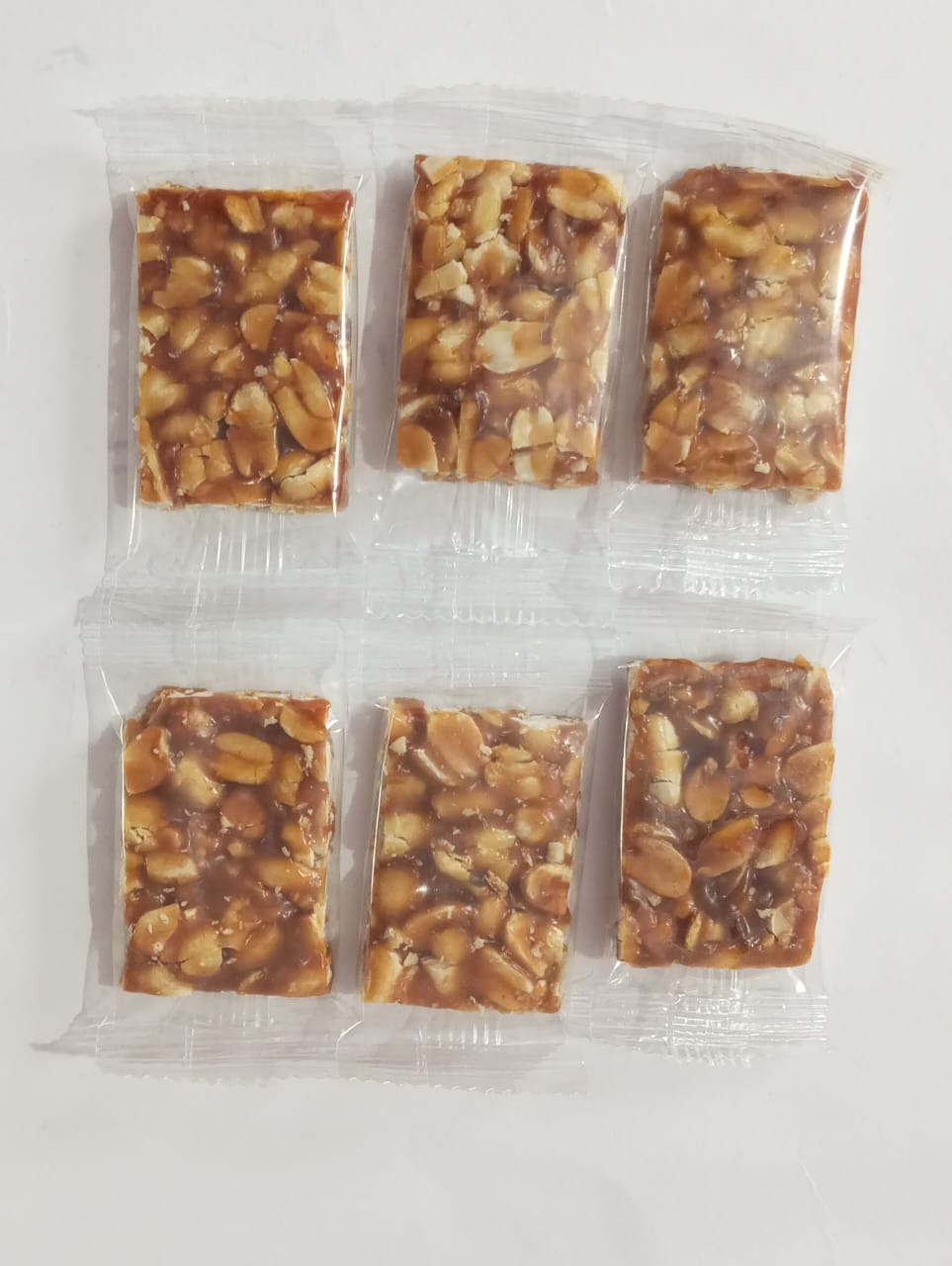 Close-up of golden crunchy, well-packed, healthy peanut chikki-Harishi